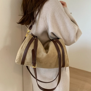 Détail du sac cabas en daim kaki avec bandoulière en cuir brun et boucle dorée