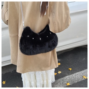 Detail of black faux fur hobo bag with silver star studs and sleek metal chain strap