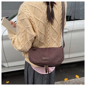 Brown frosted leather crescent bag styled in a vintage street photography setting