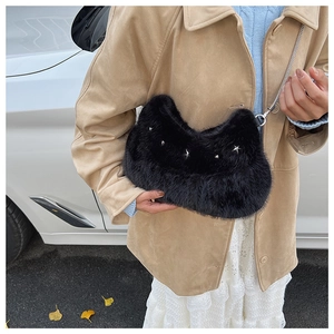 Detail of black faux fur hobo bag with silver star studs and elegant chain strap