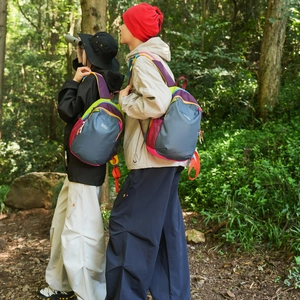 Outdoor shot showing a lightweight hiking backpack with colorful contrast panels and straps