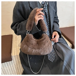 Detail of soft brown plush handbag featuring fuzzy handle and silver metal chain strap