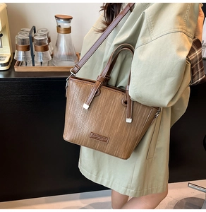 Detail of woven brown tote bag with leather handles shown in a cozy cafe setting