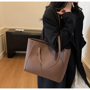 Macro shot of dark brown lychee texture leather tote bag with reinforced stitching details