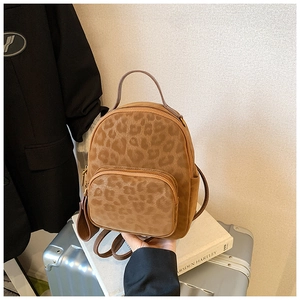 Close-up of vintage leopard print backpack with velvet texture and zipper front pocket