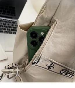 Detail of beige nylon backpack side pocket showing large smartphone storage capacity