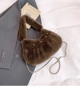 Détail du sac à main en peluche marron foncé avec clous étoiles et chaîne