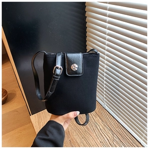 Close-up of black bucket bag featuring mixed matte and glossy textures with silver buckle