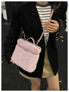 Détail du sac seau en peluche rose montrant la texture douce et la fermeture éclair argentée