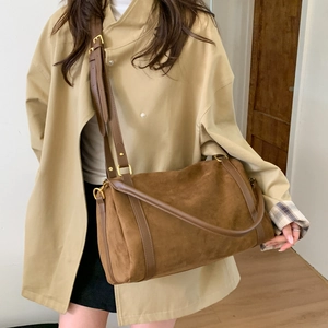 Détail du sac fourre-tout en daim marron café porté en bandoulière avec sangle