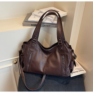 Detail of dark brown litchi pattern leather tote bag with double zippers and long strap