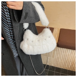 Detail of white faux fur shoulder bag with silver star studs and metal chain strap