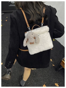 Détail de la texture peluche blanche et bandoulière en cuir du sac seau avec lapin peluche