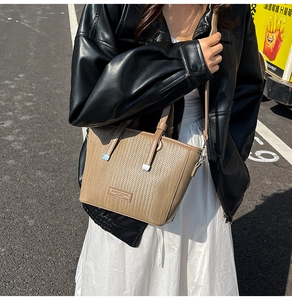 Detail of khaki woven texture on a women's bucket bag with silver metal accents
