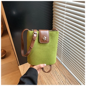 Close-up of avocado green bucket bag with leopard print accent and adjustable strap