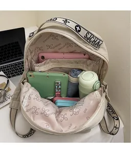 Spacious interior of beige nylon backpack showing organized storage for tablet and bottles