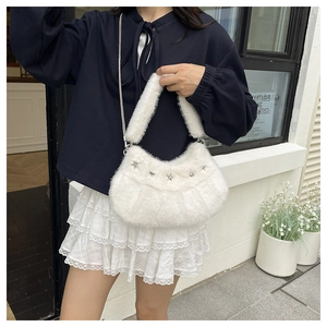Détail du sac hobo en peluche blanche avec clous étoiles et bandoulière en chaîne