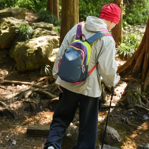 Detail of color-block mini hiking backpack with breathable side mesh pockets in nature