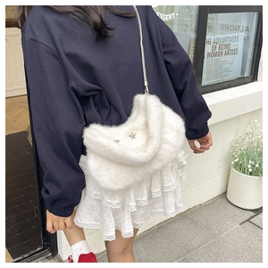 Détail du sac bandoulière en fausse fourrure blanche avec étoile et chaîne argentée