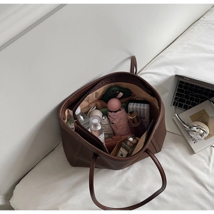 Deep brown pebble leather tote bag showing spacious interior with various everyday items