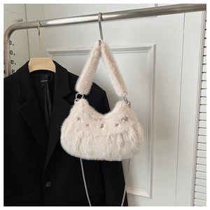 Close-up of fluffy off-white plush bag with silver star rivets and elegant metal chain
