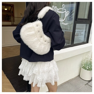 Photo de rue d'un sac à bandoulière en fausse fourrure blanche avec étoiles argentées
