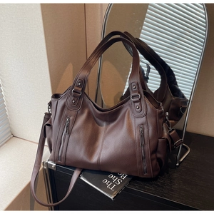 Detailed view of large dark brown tote bag with premium lychee grain texture and zippers