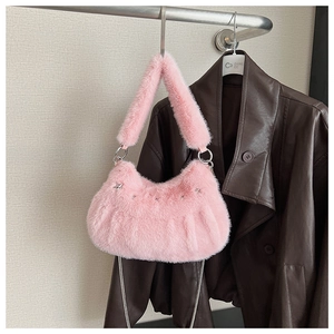 Detailed shot of pink faux fur moon bag with metallic star charms and fluffy handle