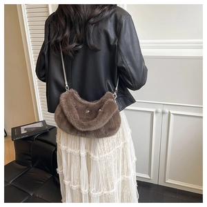 Détail d'un sac bandoulière en fausse fourrure marron avec étoile et chaîne argentée