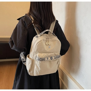 Detailed back view of a beige nylon backpack with SJCHAO woven straps and zipper