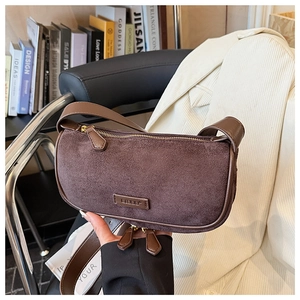 Detail of vintage brown suede shoulder bag with gold zipper and premium leather texture