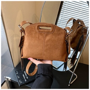 Detail of brown faux suede crossbody bag with long side tassels and adjustable strap