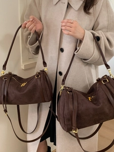 Sac Boston cylindrique en daim marron en deux tailles avec détails en métal doré