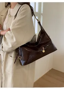 Close-up of deep brown oil wax leather tote bag with vintage golden ring and zipper detail