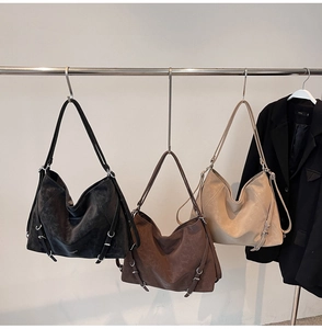 Detail view of large tote bags in three colors with metallic buckles and adjustable straps