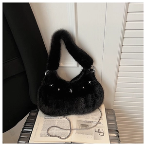 Detail of plush black faux fur handbag with silver star studs and metal chain strap