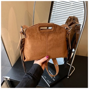 Close-up of brown frosted suede crossbody bag with retro fringe and metal buckle