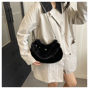 Détail du sac croissant en peluche noire avec trois rivets étoiles argentés et bandoulière