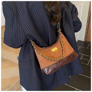 Close-up of vintage-style patchwork dumpling bag with chain strap and metal lock