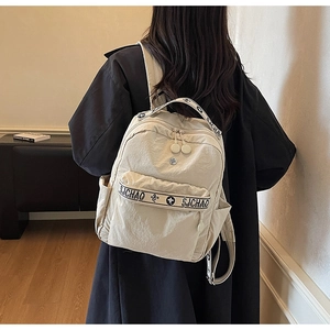 Detailed view of beige nylon backpack with SJCHAO jacquard straps and dual zippers