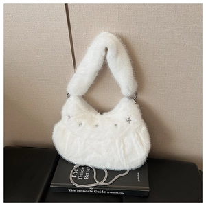 Detail of white faux fur handbag featuring silver star studs and metal chain strap