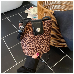 Close-up of leopard print bucket bag with black leather flap and metal snap button