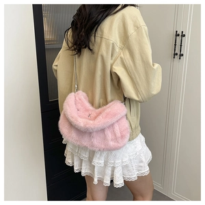 Gros plan d'un sac à bandoulière en fausse fourrure rose avec chaîne en métal