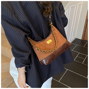 Close-up of brown quilted leather bag featuring gold twist lock and chain strap detail