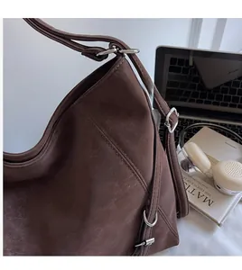 Detail view of the retro dark brown tote bag featuring silver buckles and smooth shoulder strap