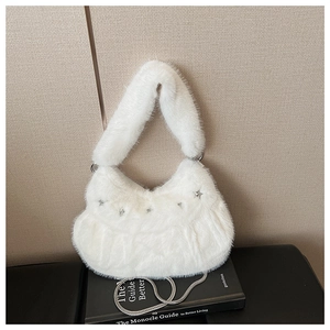 Detail of white plush crescent bag with silver star charm and metallic chain strap