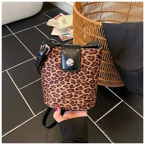Close-up of leopard print bucket bag with black leather flap and silver buckle