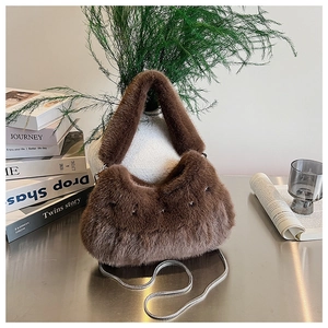Detail of soft brown faux fur handbag with metal chain on a minimalist table