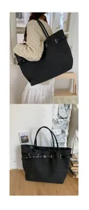 Detail view of black canvas tote bag with grommet leather strap and vintage metal buckle