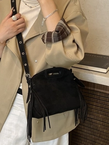 Retro black faux suede crossbody bag with fringe details and a silver eyelet strap